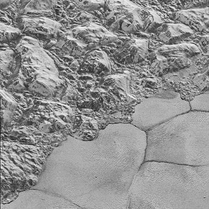  Mountains of ice along a portion of smoother ice planes on Pluto’s surface.